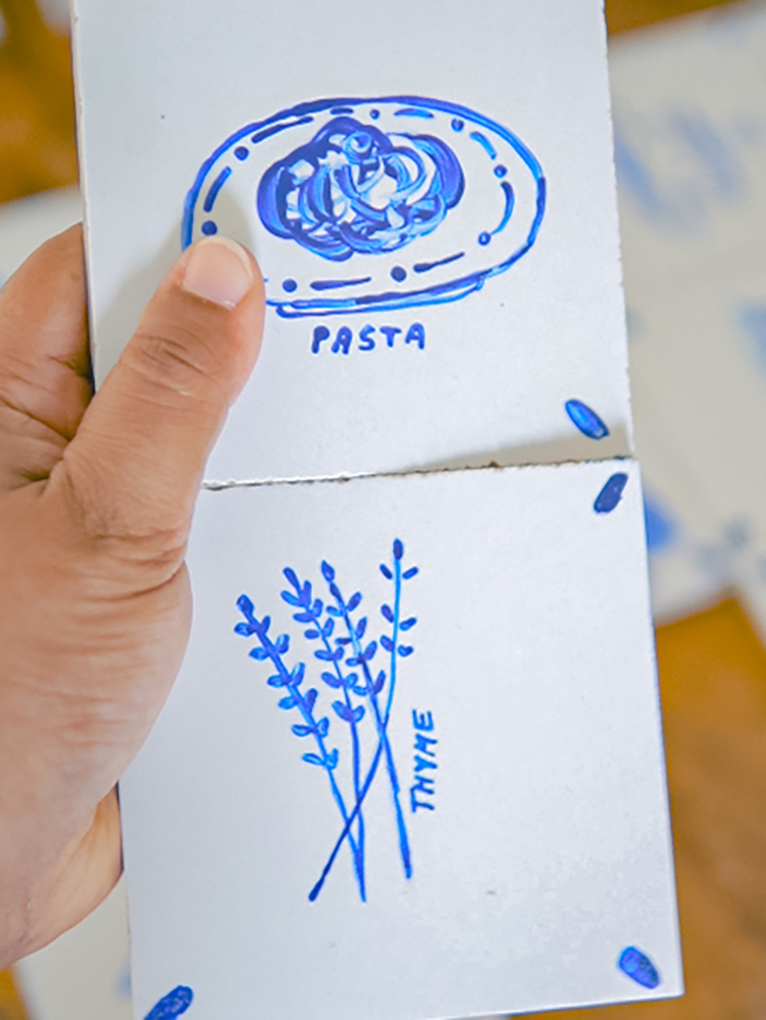 person holding white tiles with blue designs