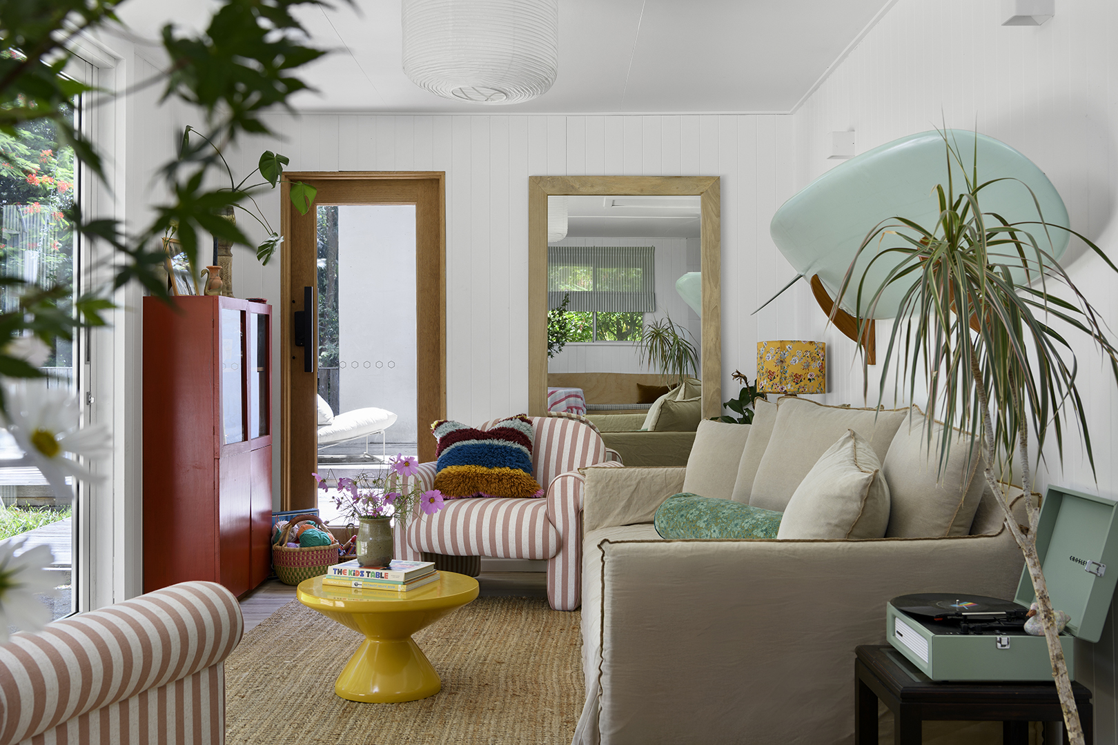 living room with yellow coffee table and red bookshelf