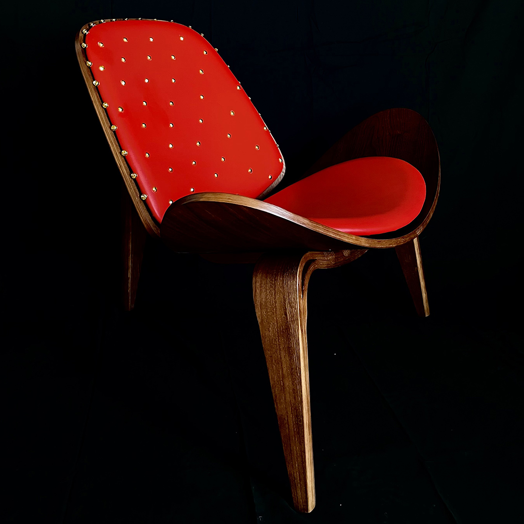 curved midcentury chair with red upholstery and gold details