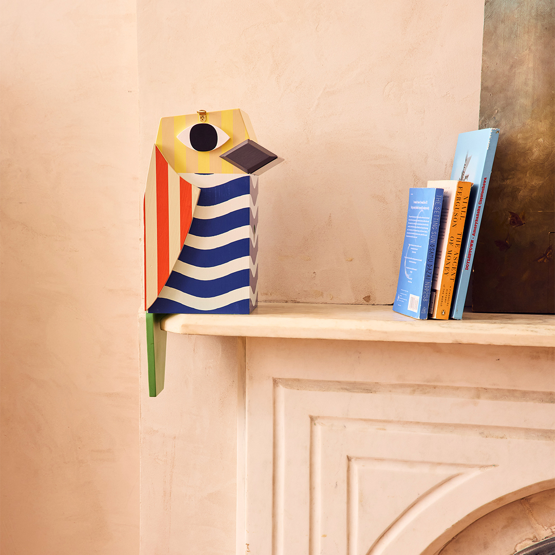 colorful wooden birdhouse on mantle