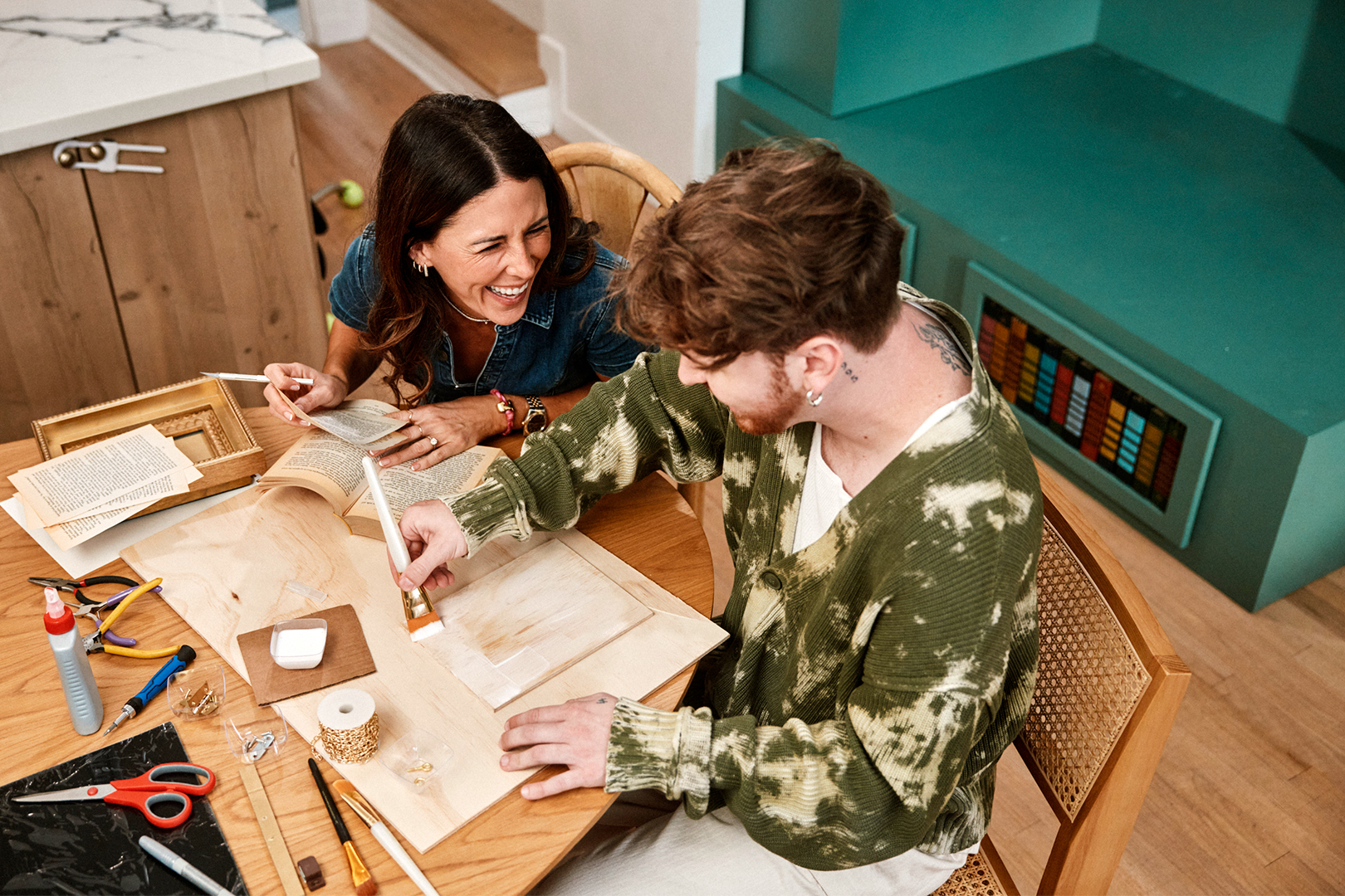 woman and man working on a craft at a dining table