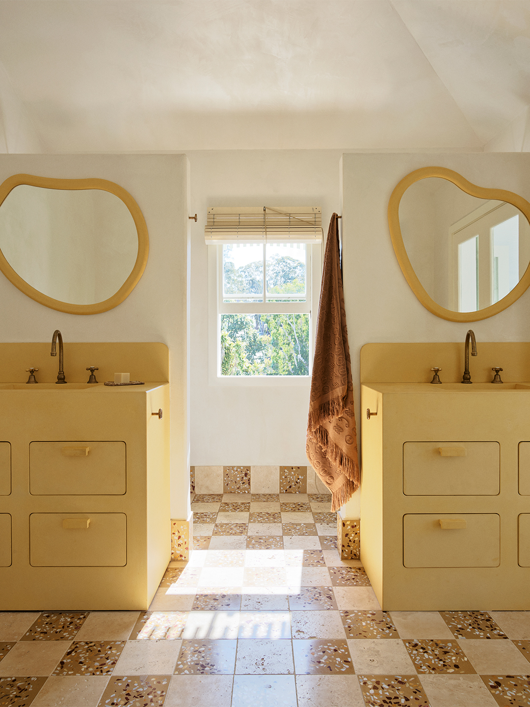 bathroom with matching yellow vanities and oblong mirrors