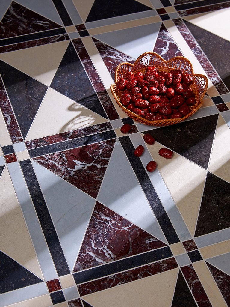 marble tiles with basket of red fruit on top
