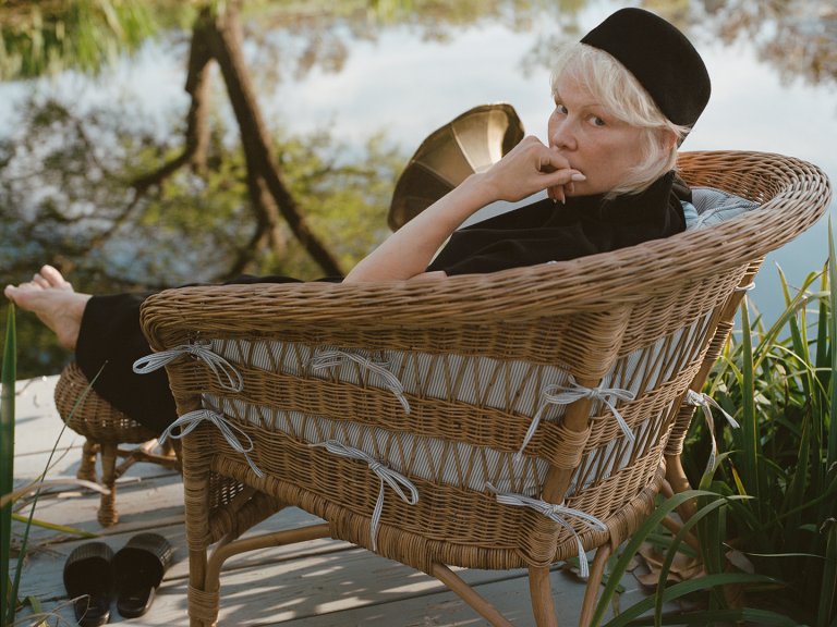 pamela anderson sitting in a rattan chair