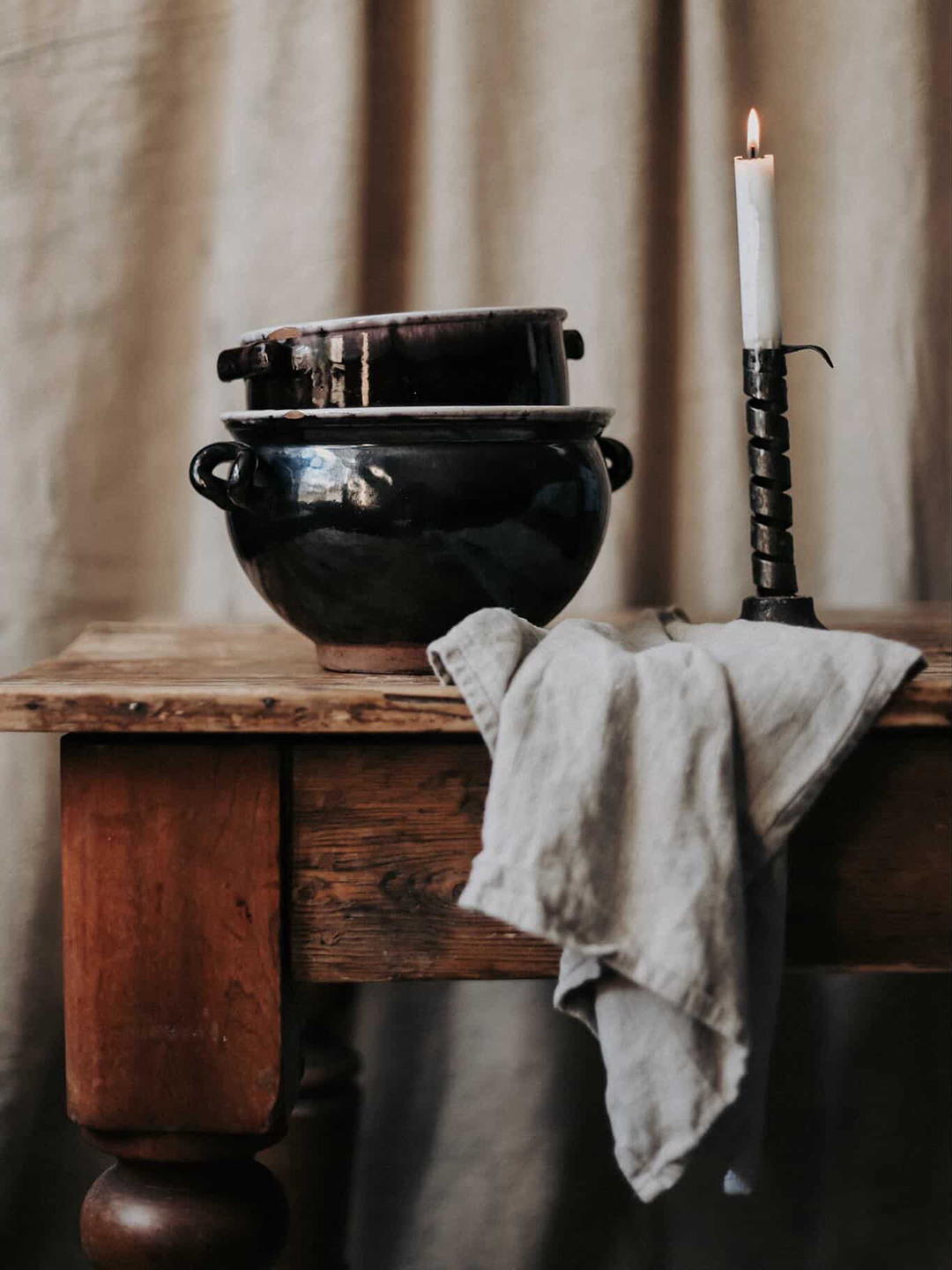 two black-bottom earthenware pots on a table