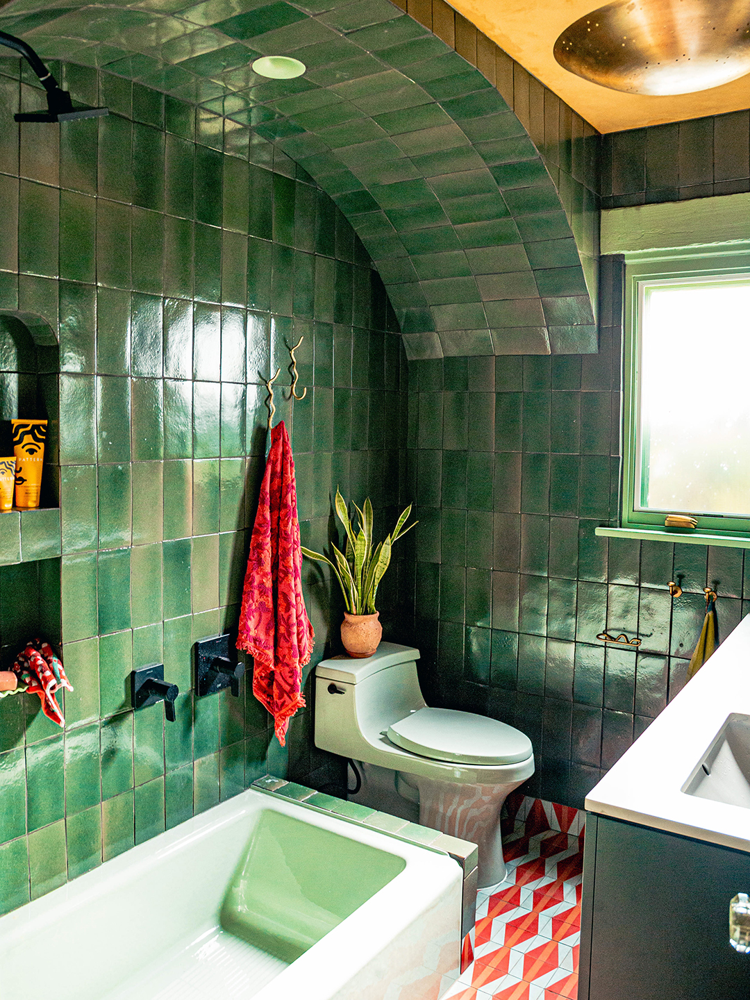 green-tiled bathroom with green tub and toilet
