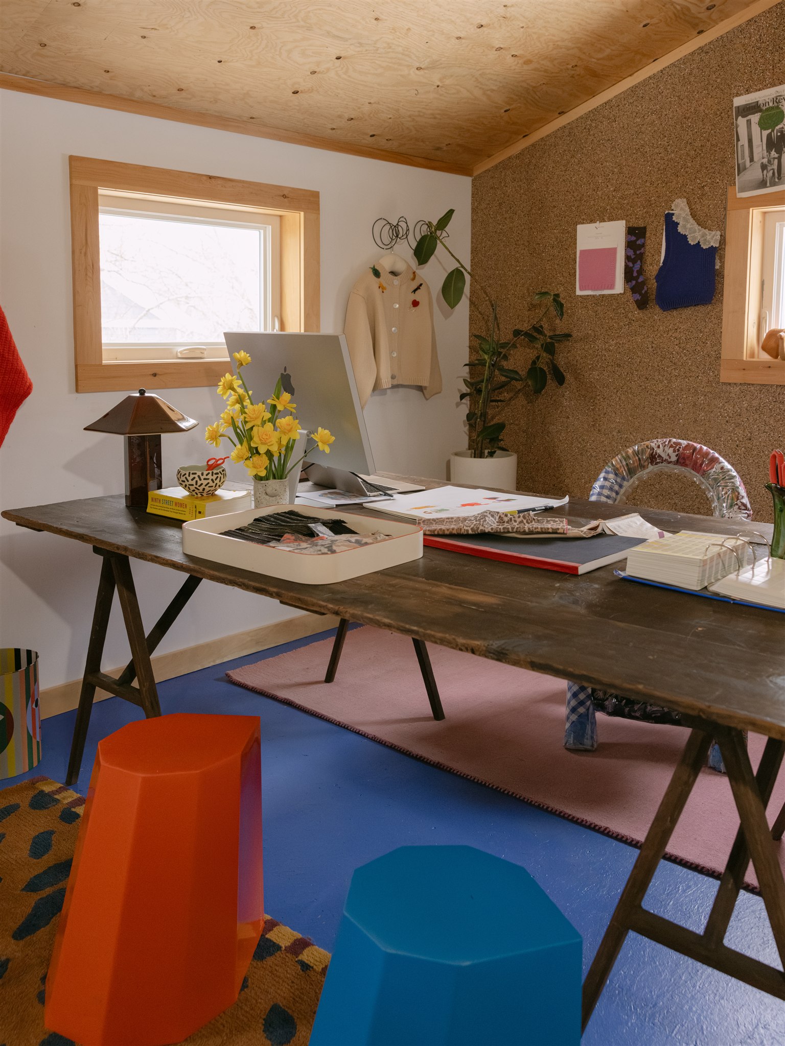 colorful room with large wood desk and cork wall 