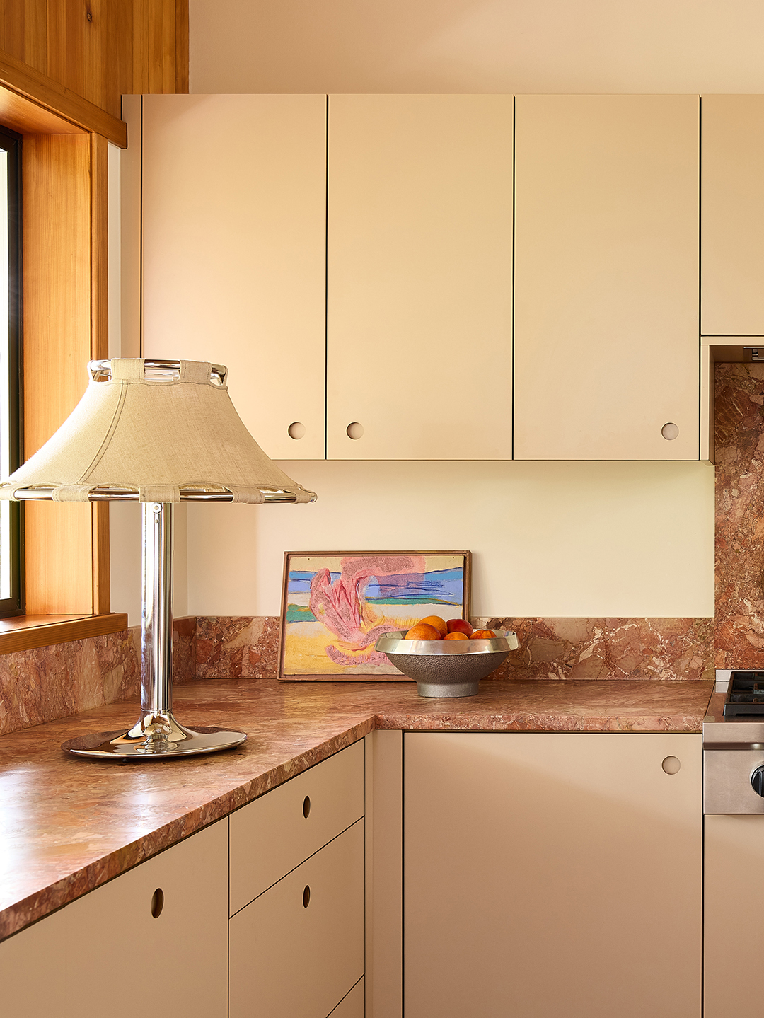 creamy yellow kitchen with pink marble backsplash and counters