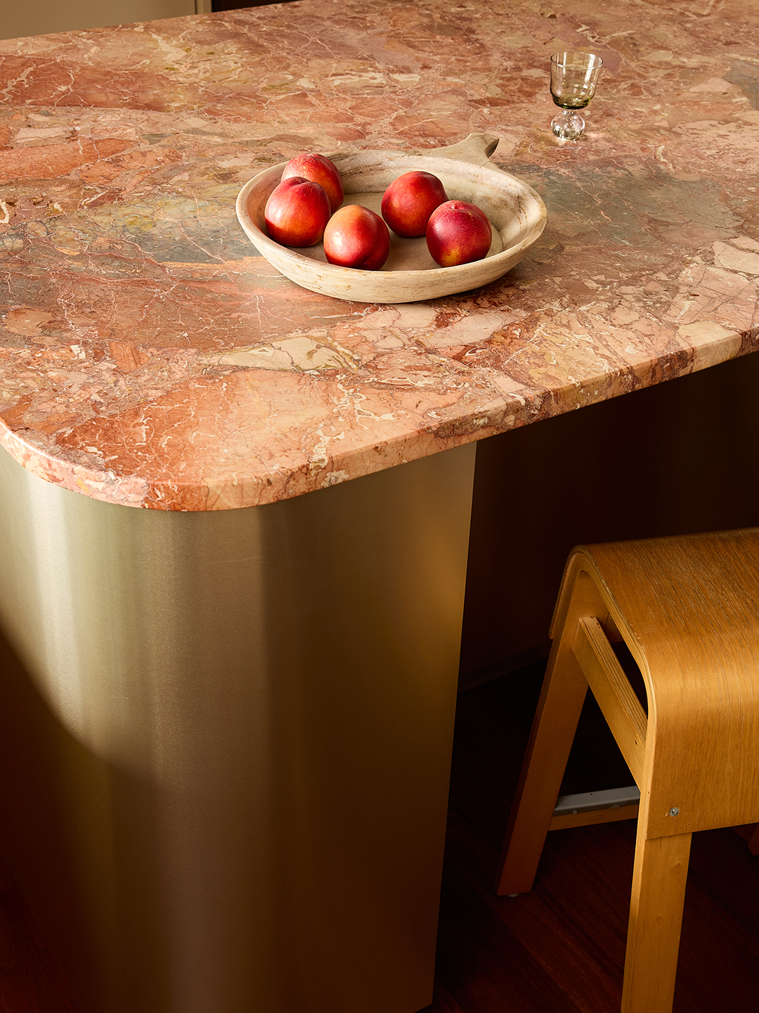 island countertop with pink marble and dish of apples
