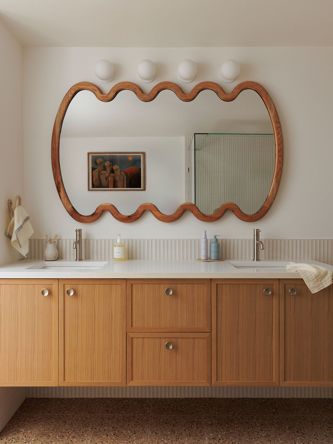 bathroom with squiggly mirror and wood vanity
