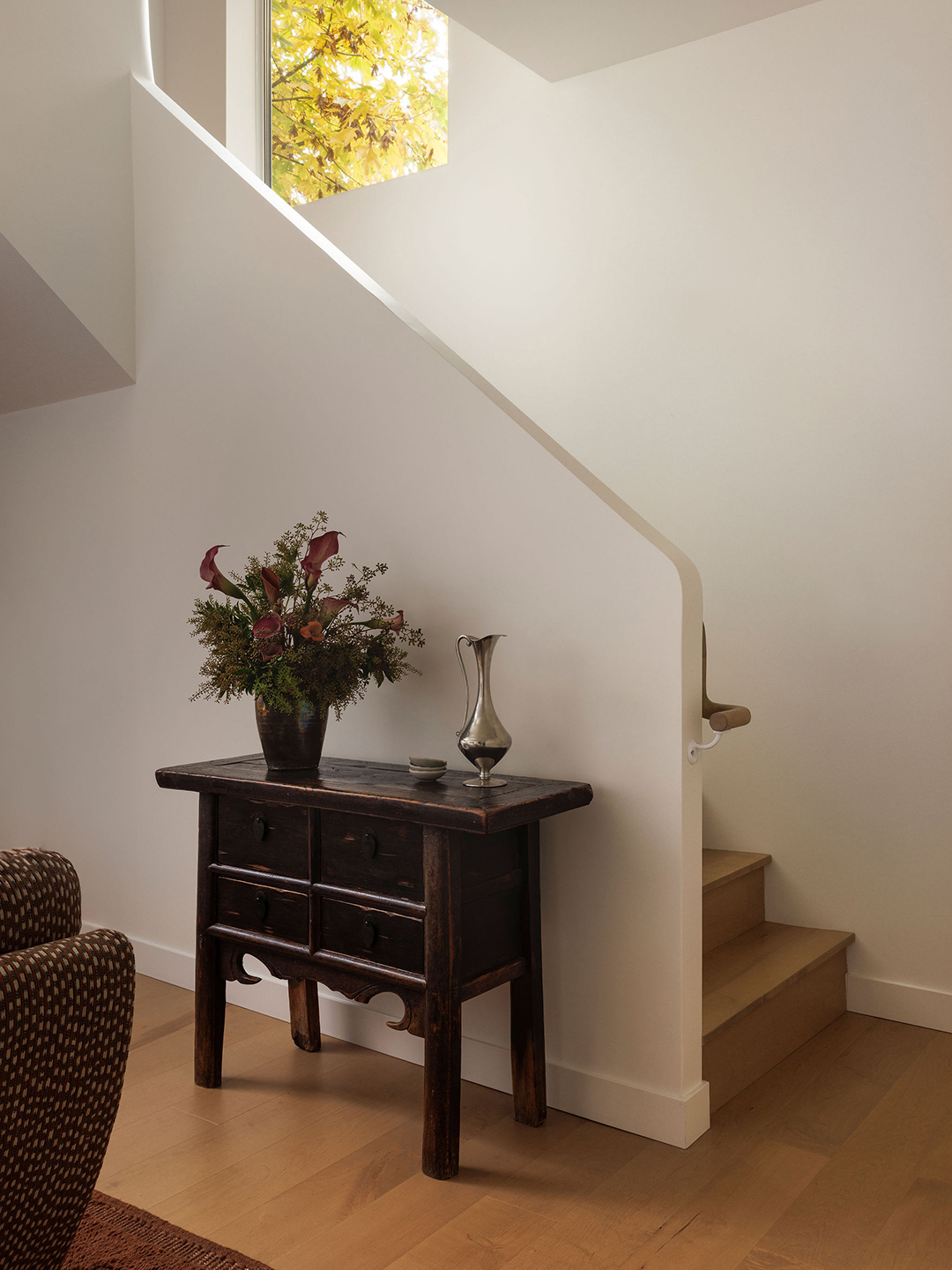 white stair area with wood console