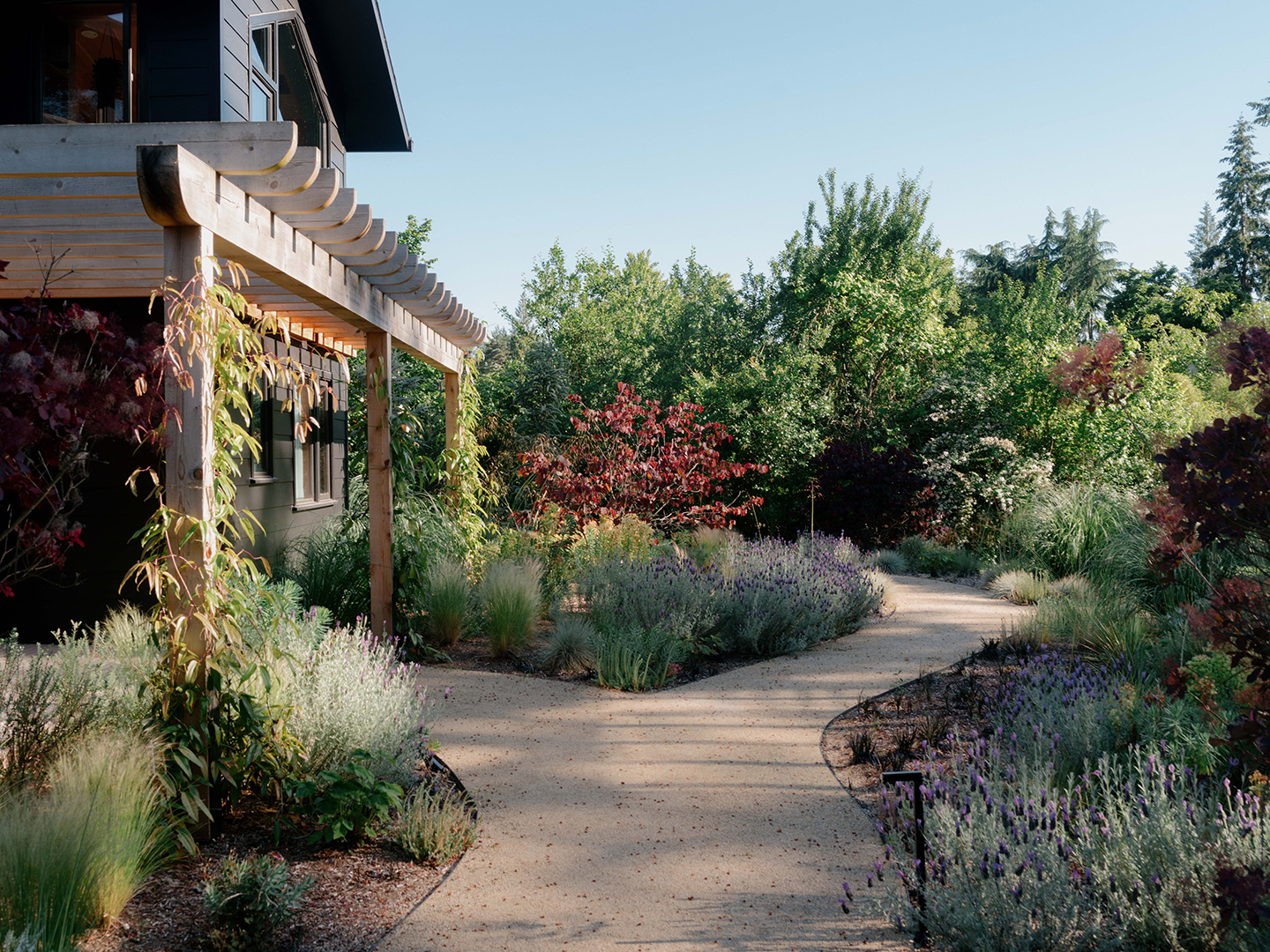 walkway with lush flower beds leading to entry of house