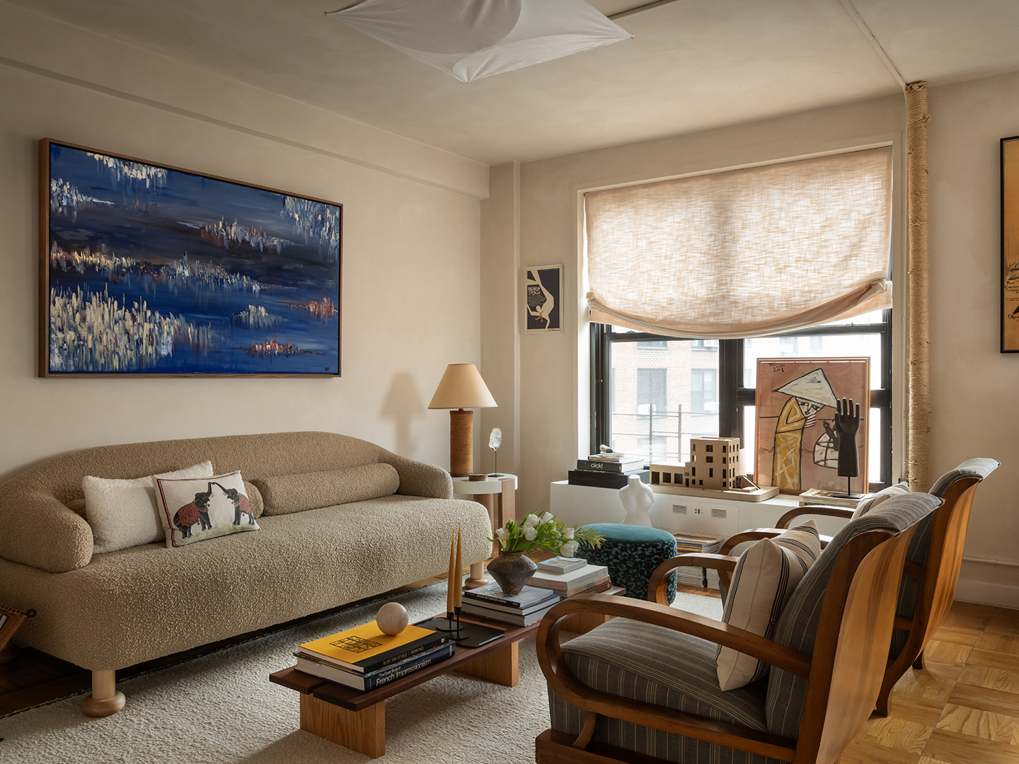 living room with artwork and beige sofa and two chairs