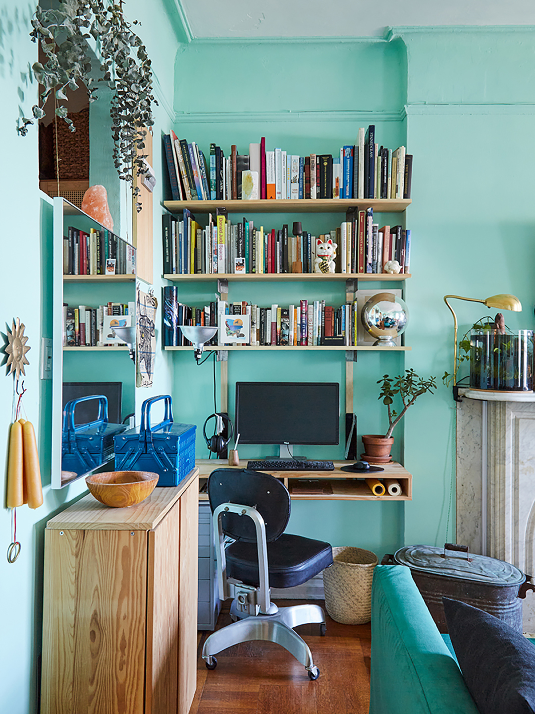 teal room with desk and shelf in corner