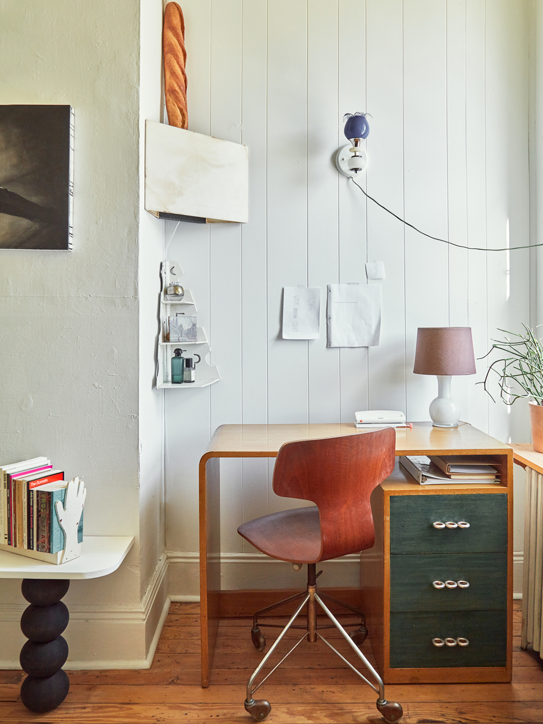 small wood desk tucked in corner