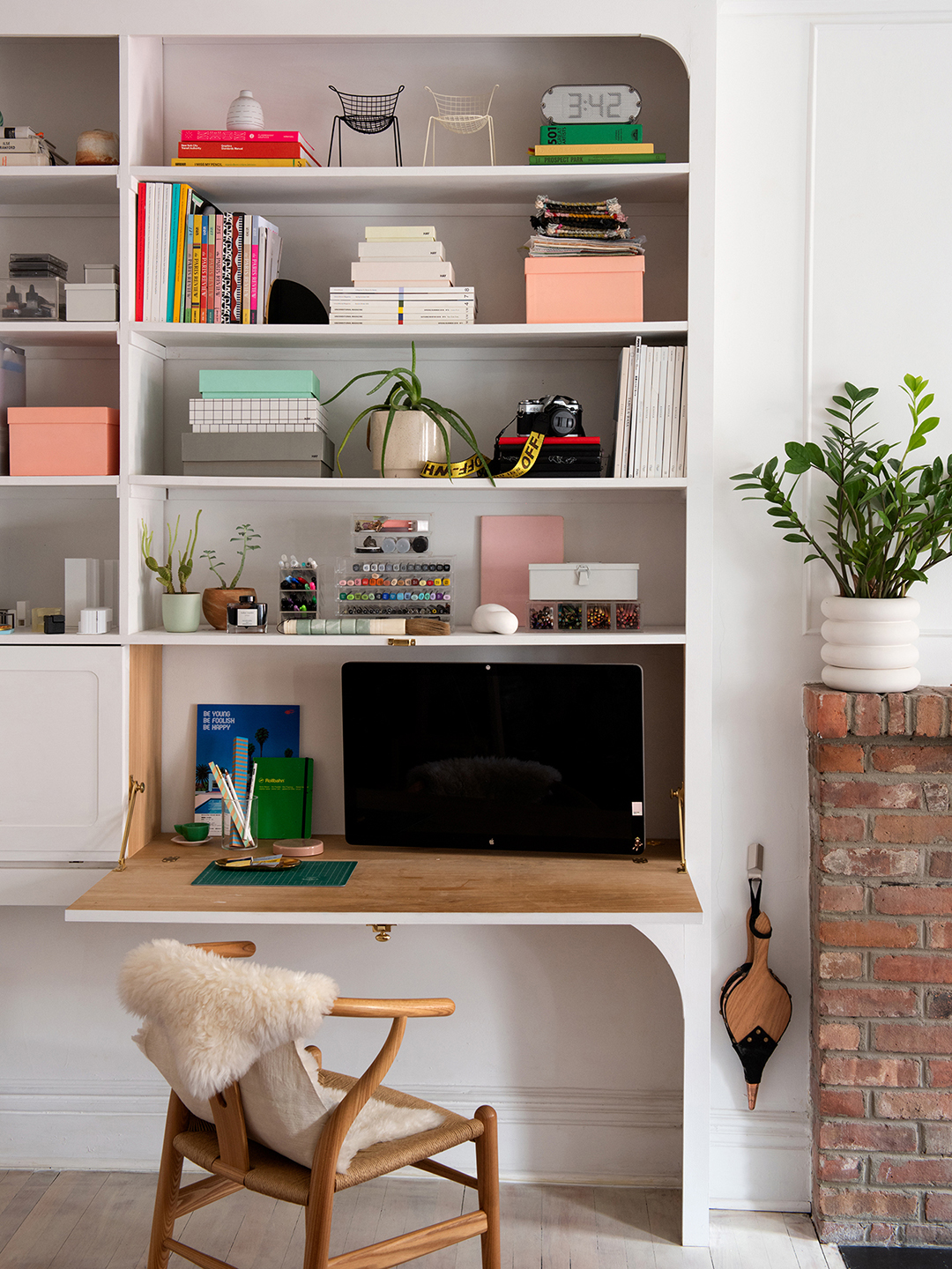 white bookcase with drop down desk and monitor