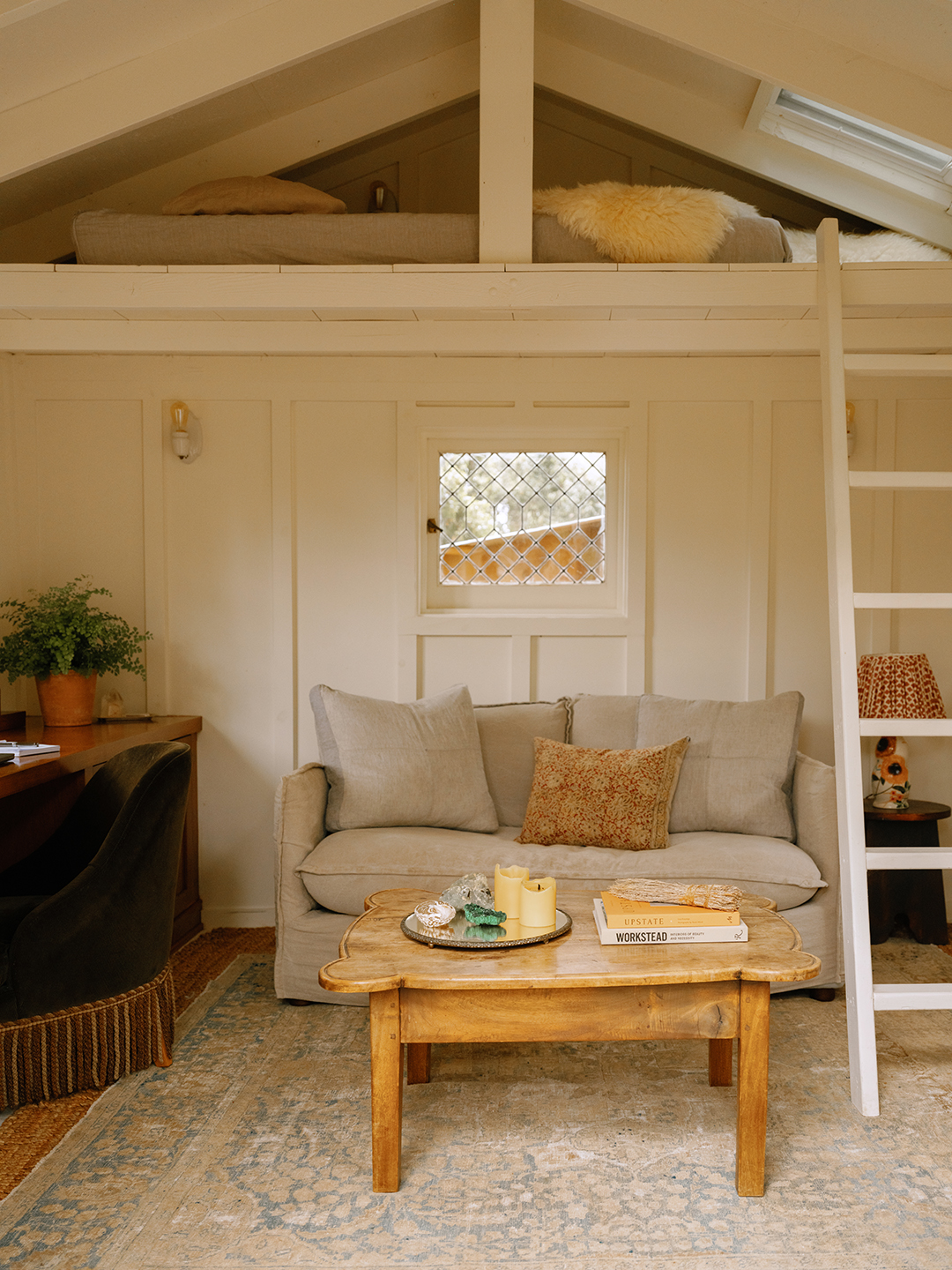lofted space with small sofa and wood coffee table