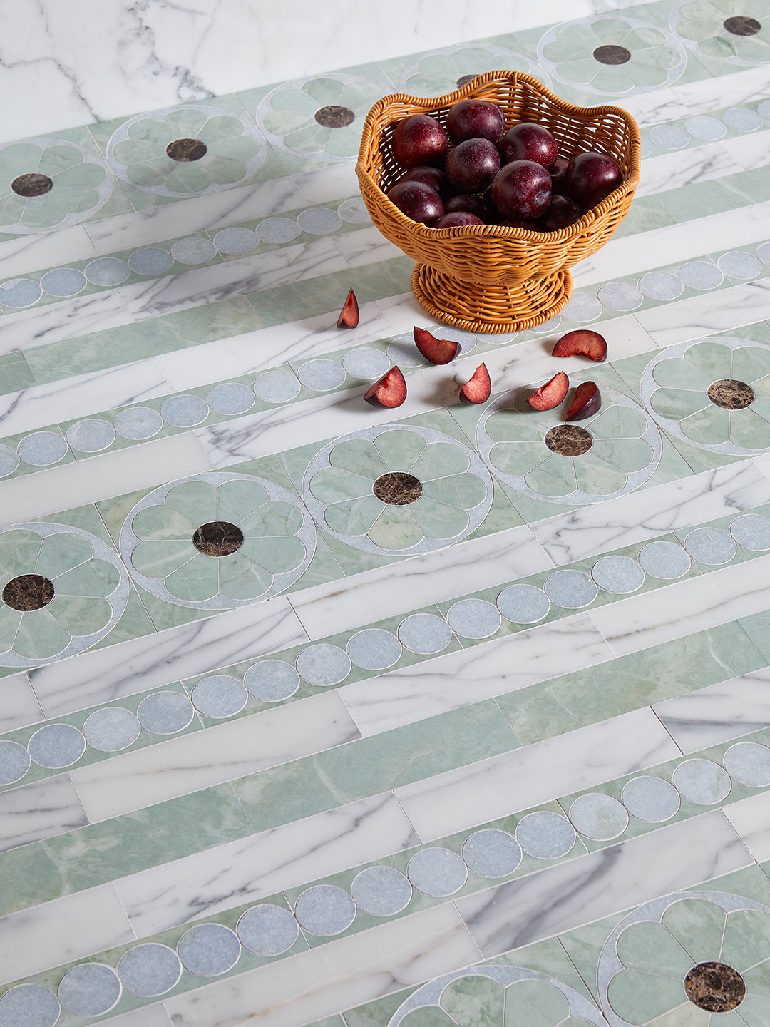 marble tile with flower and circle pattern and a basket of plums