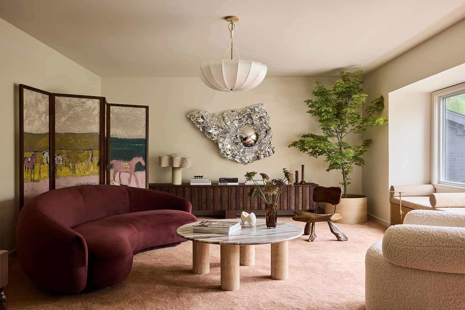 living room with metallic silver art on wall and curved seating