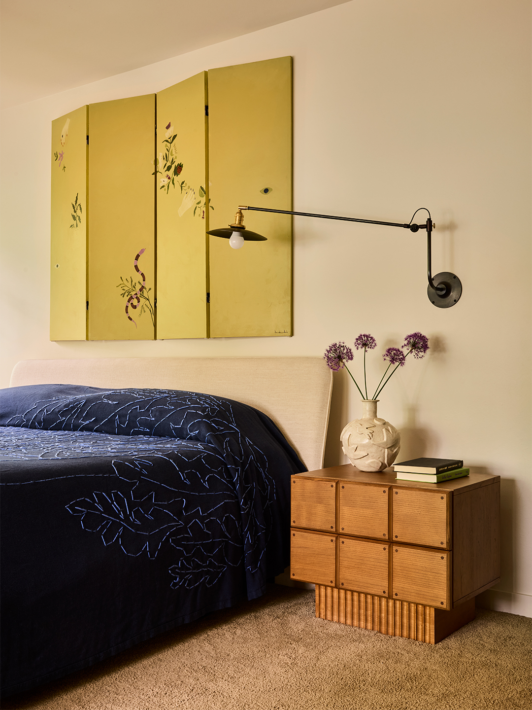 bedroom with paneled artwork above the bed