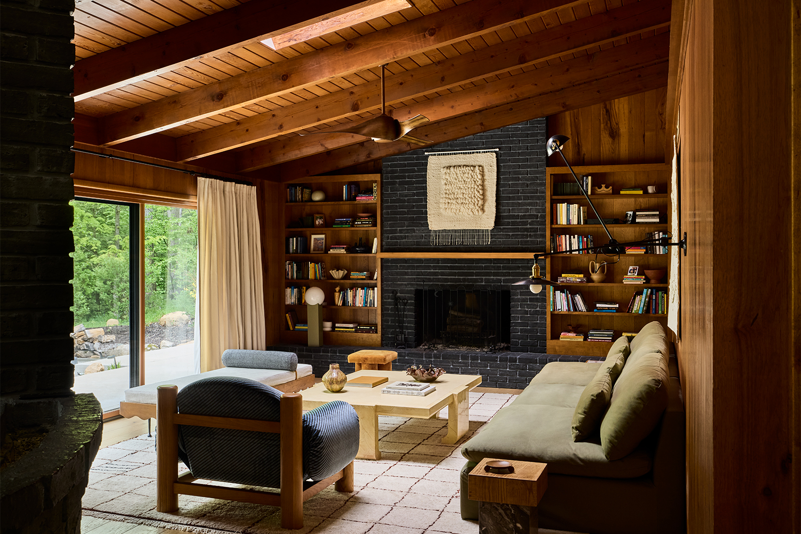 warm wood den with slanted ceiling and black hearth