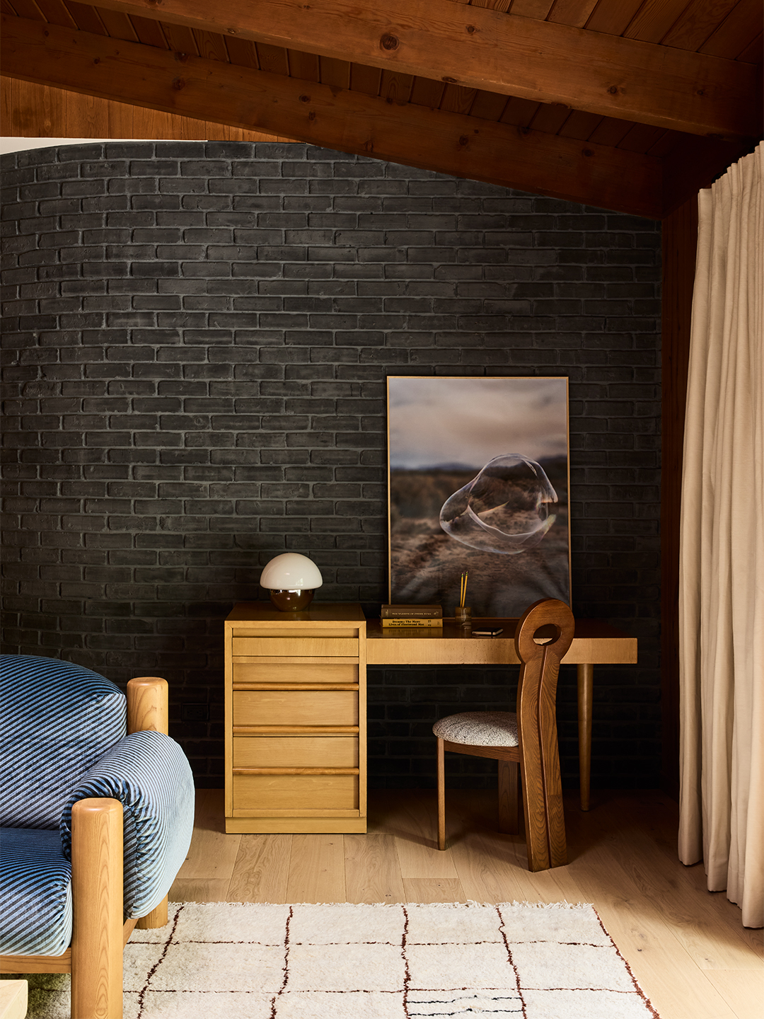 Wooden desk in a black brick room