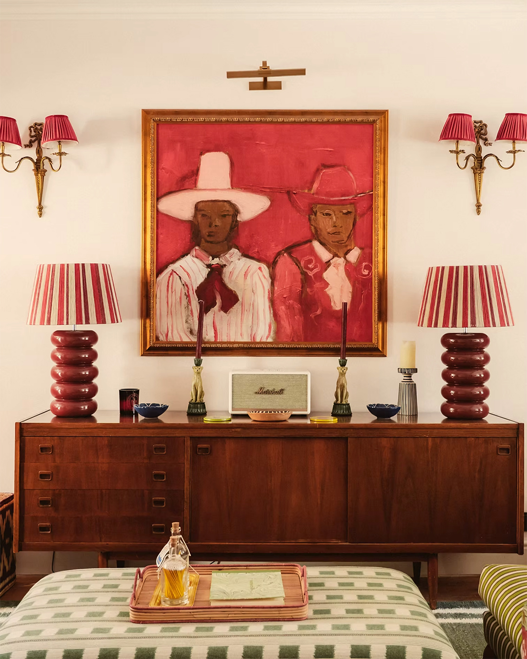 credenza with two lamps and two sconces and painting in middle