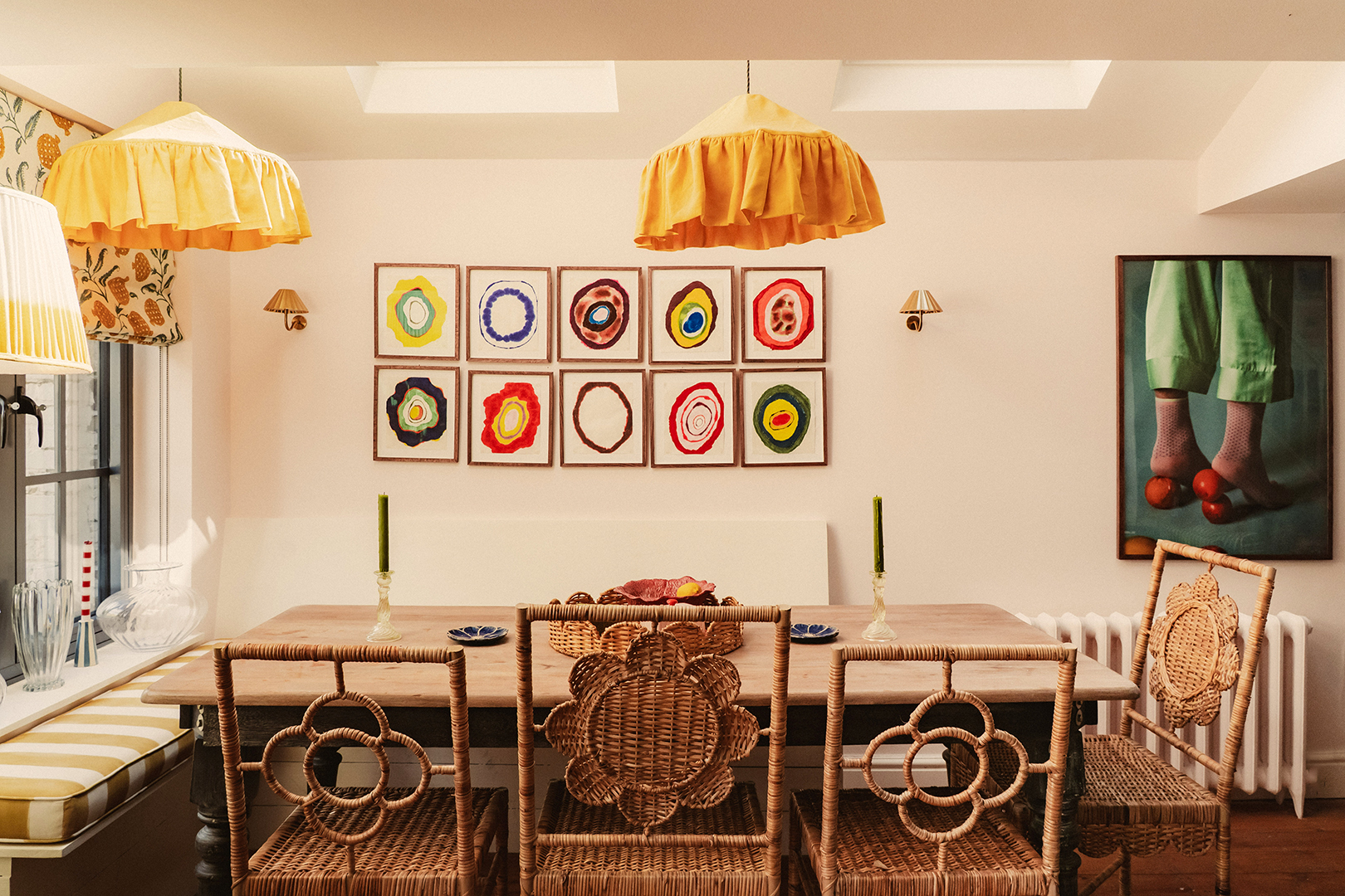 dining room with rattan chairs, yellow light fixtures, and art on walls
