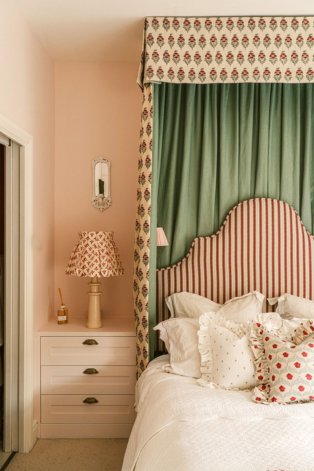 bedroom with pink walls and fabric canopy detail