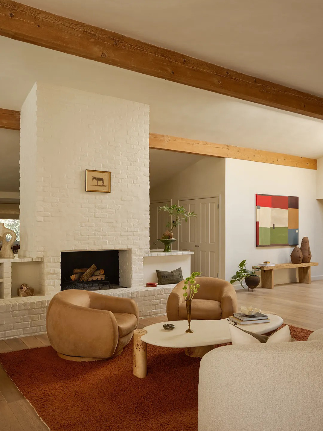 living room with white brick fireplace and exposed beams