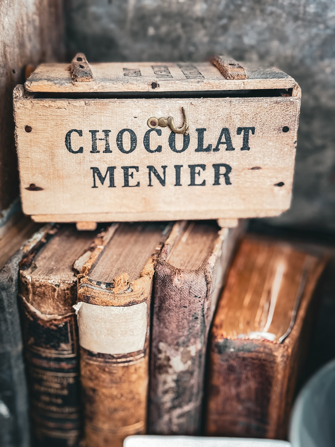 wooden "chocolate Menier" box on top of a stack of books