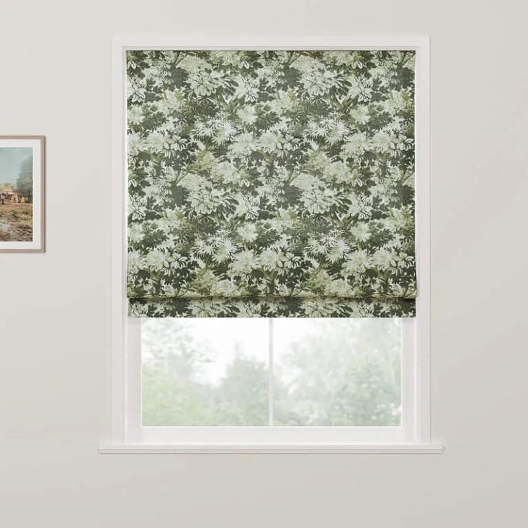 Window with Roman shade in green floral pattern.