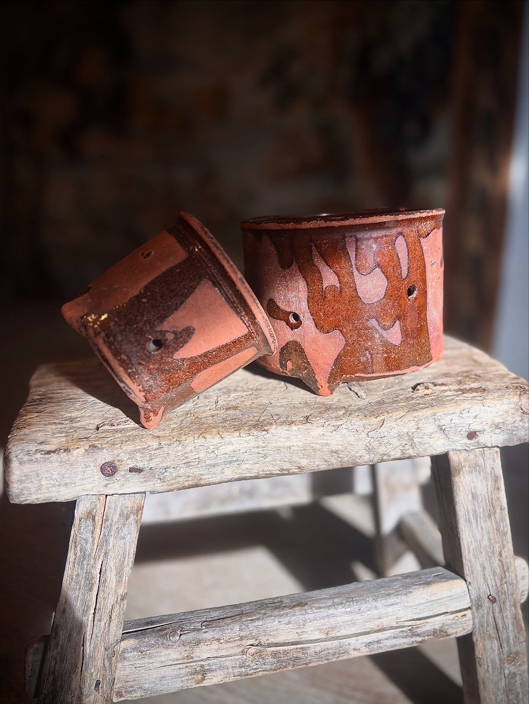 two earthenware pots on a stool