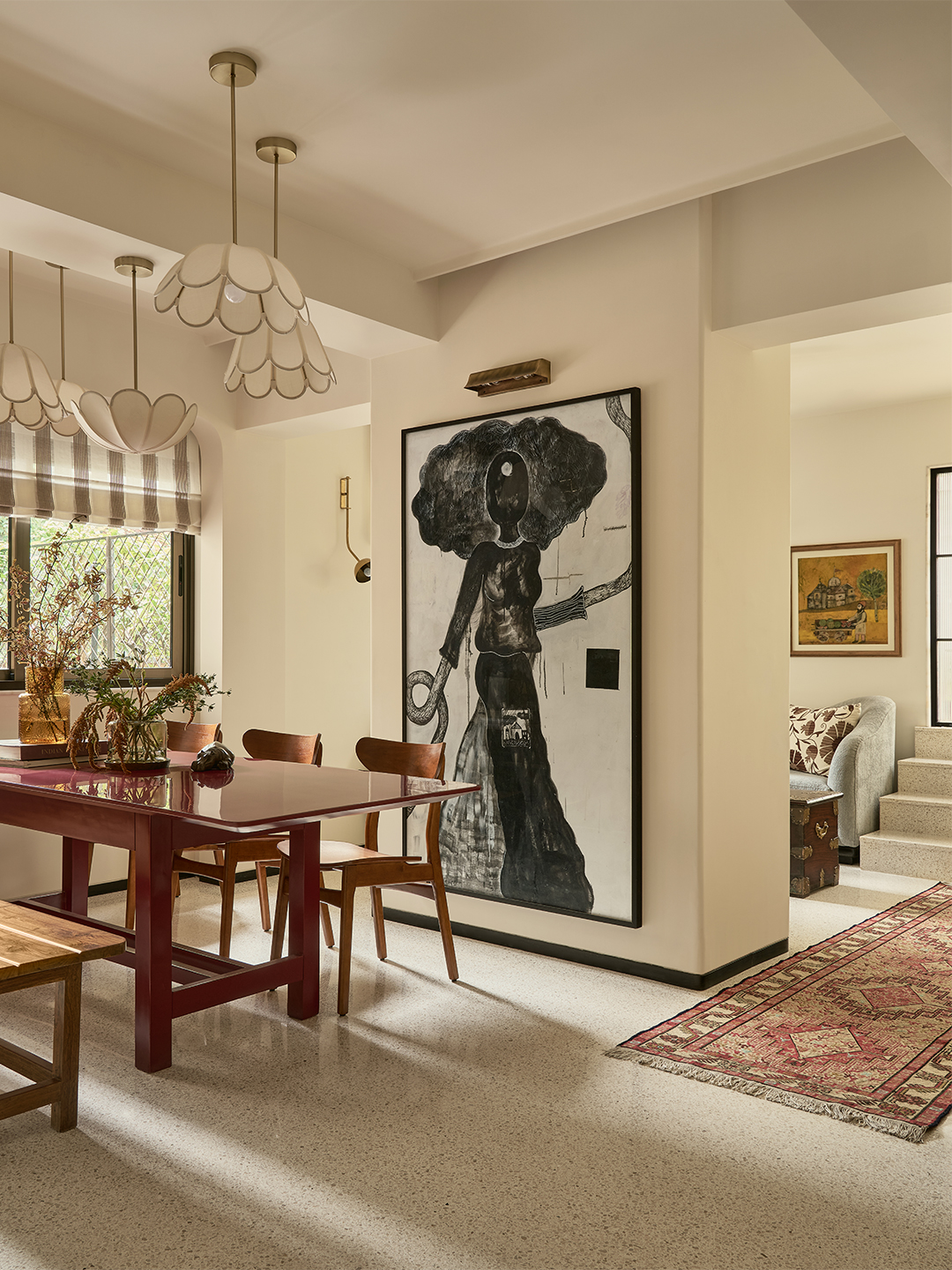 large artwork in dining room with red table