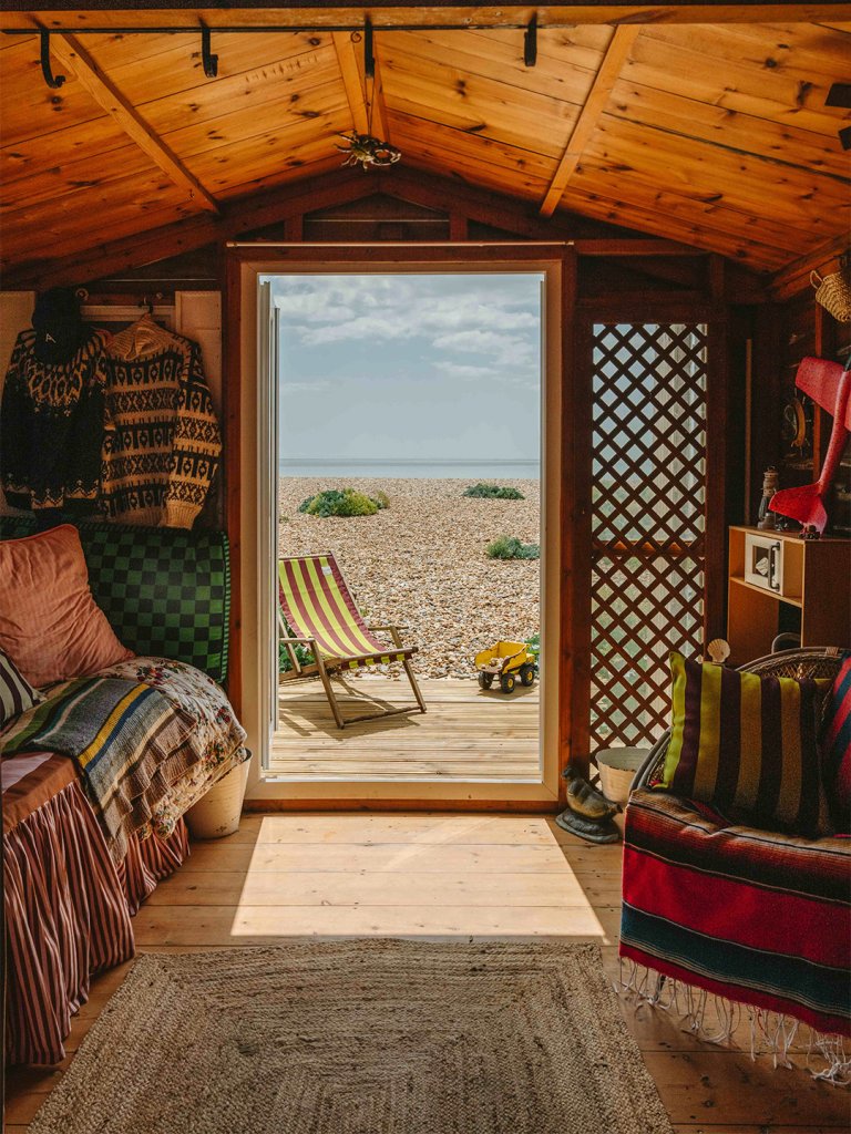 view out of beach hut with striped chair on the deck