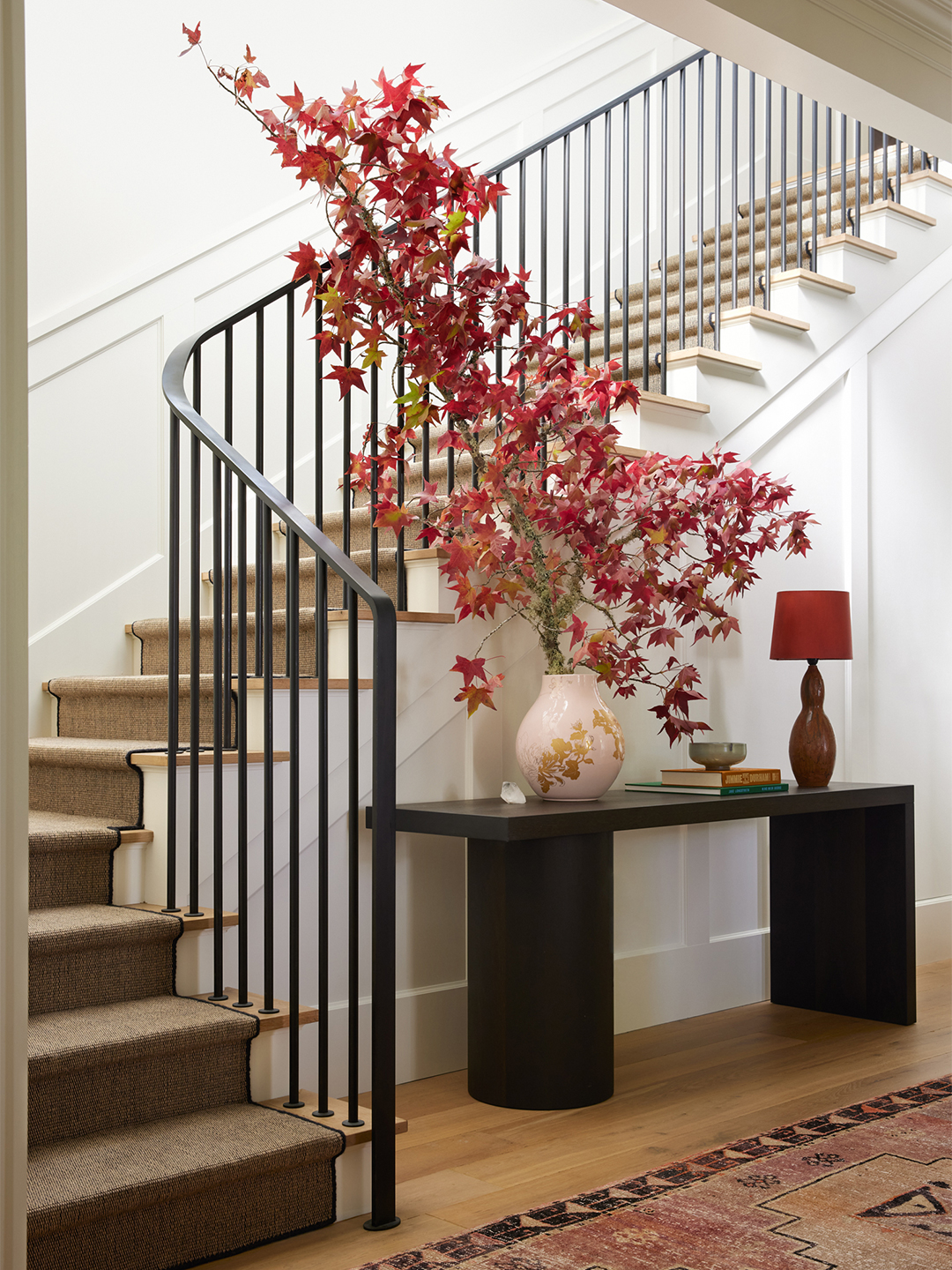staircase with black console table at base