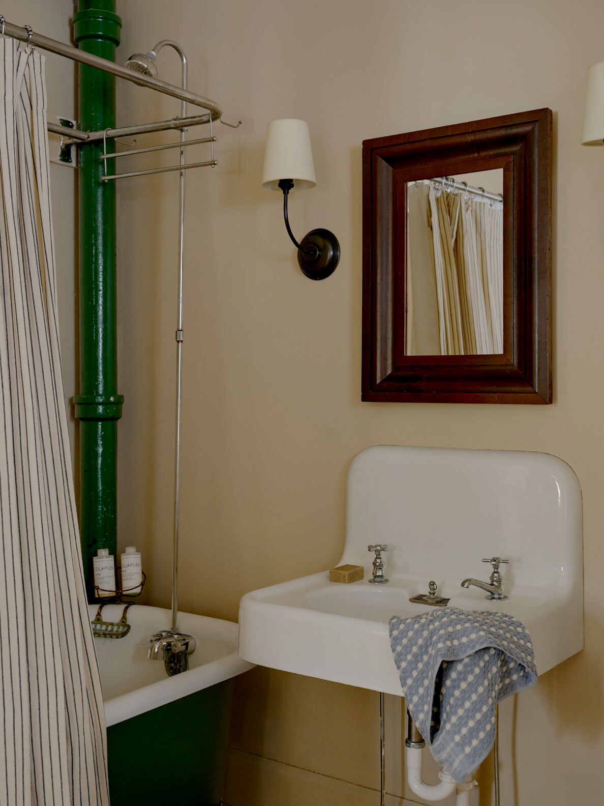 bathroom with green pipe and tub and white sink