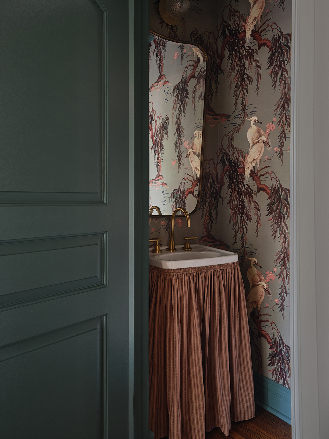 powder room with wallpaper and skirted sink