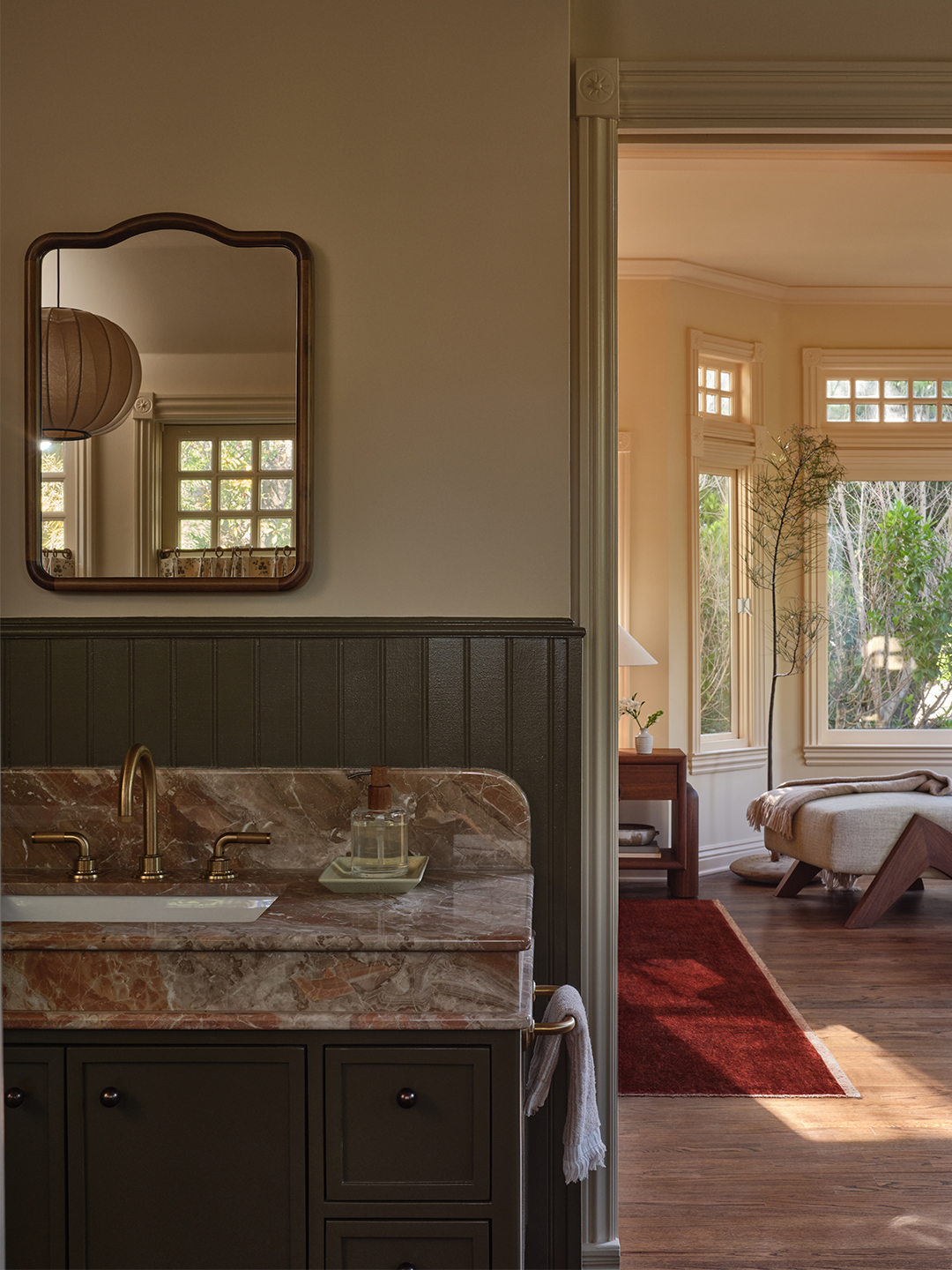 bathroom with pink marble counter and view into bedroom
