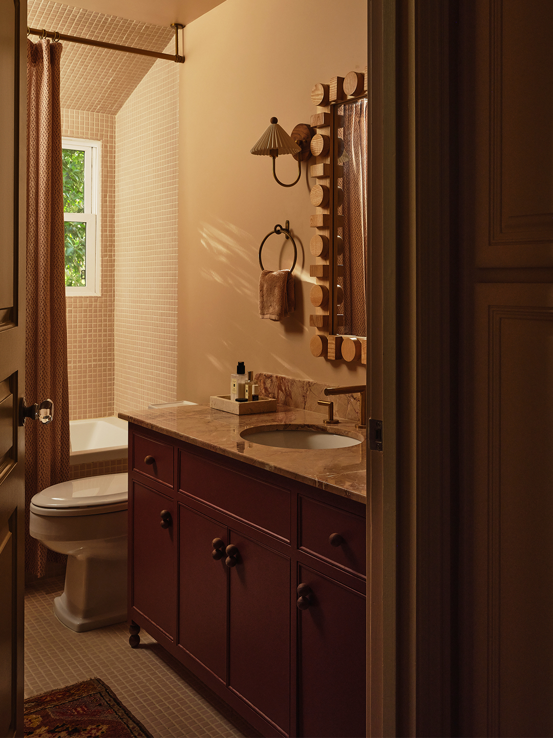 bathroom with large vanity, tiled shower, and wooden mirror