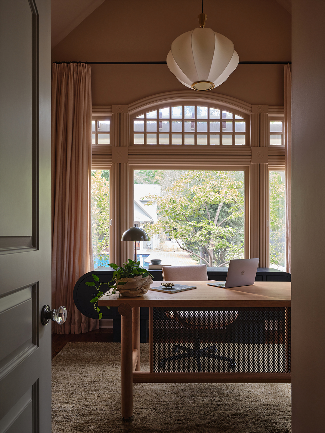 light pink office with desk and laptop