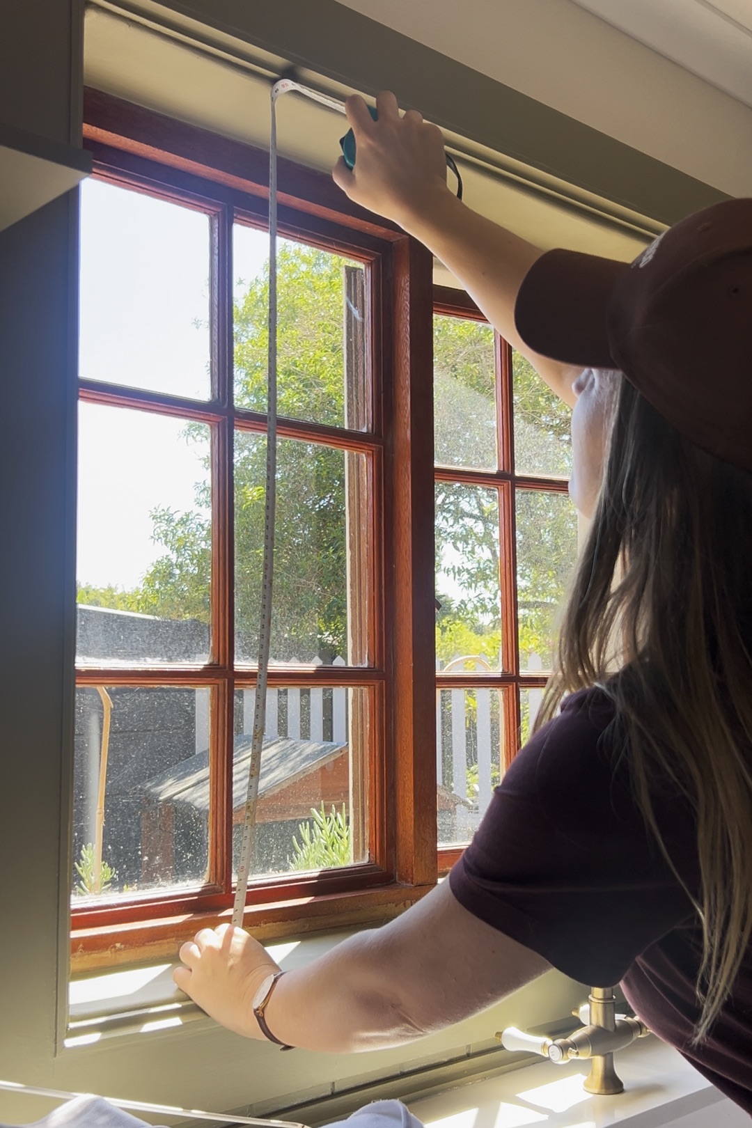 woman measuring a window using a tape measure