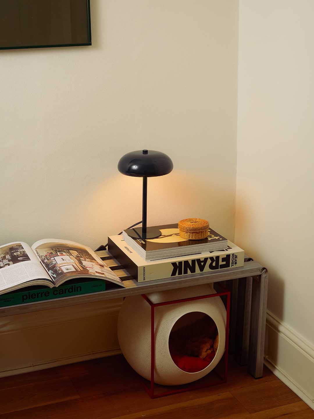 low bench with books and light stacked on it