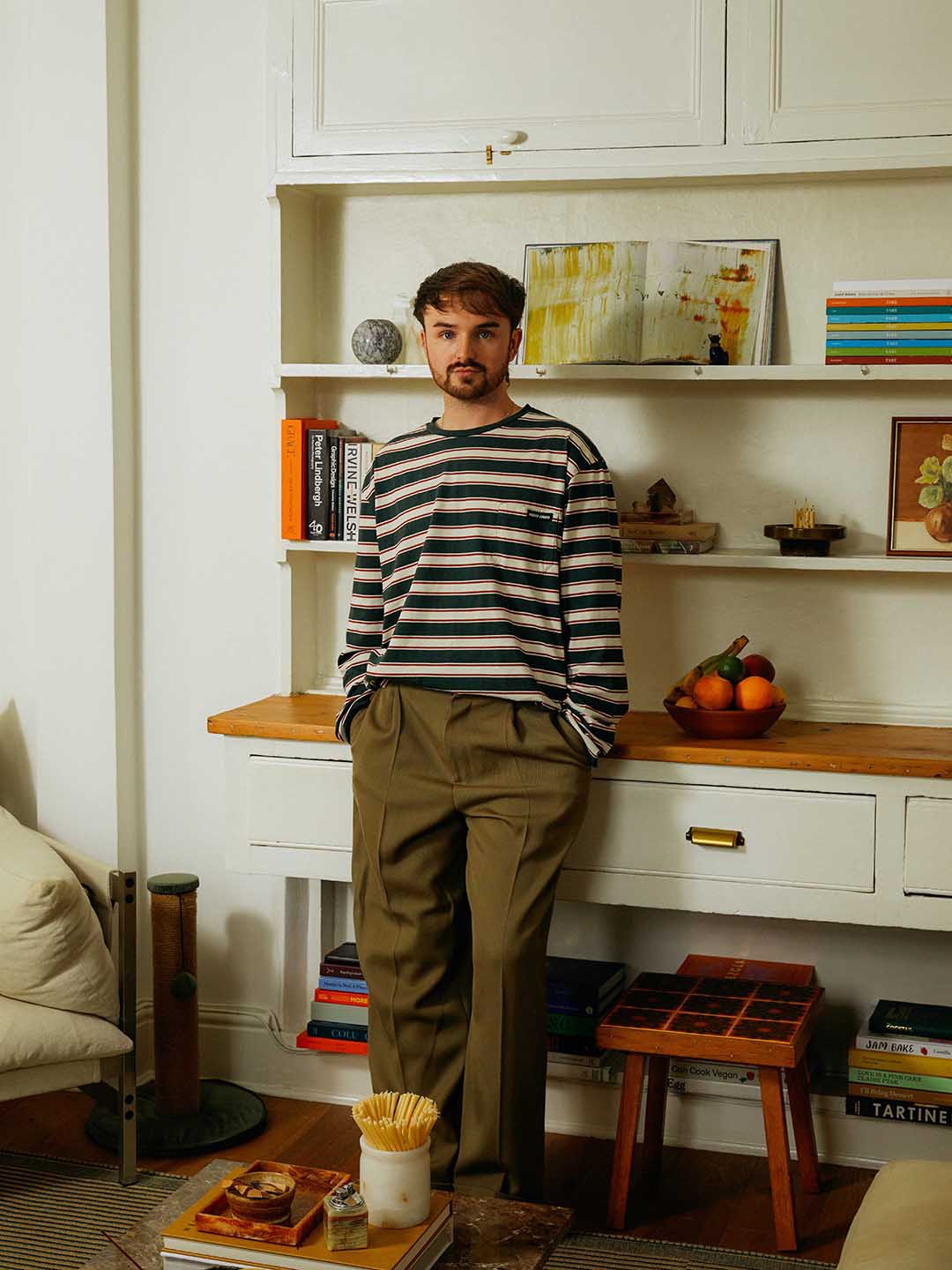man standing against a wall of open shelving