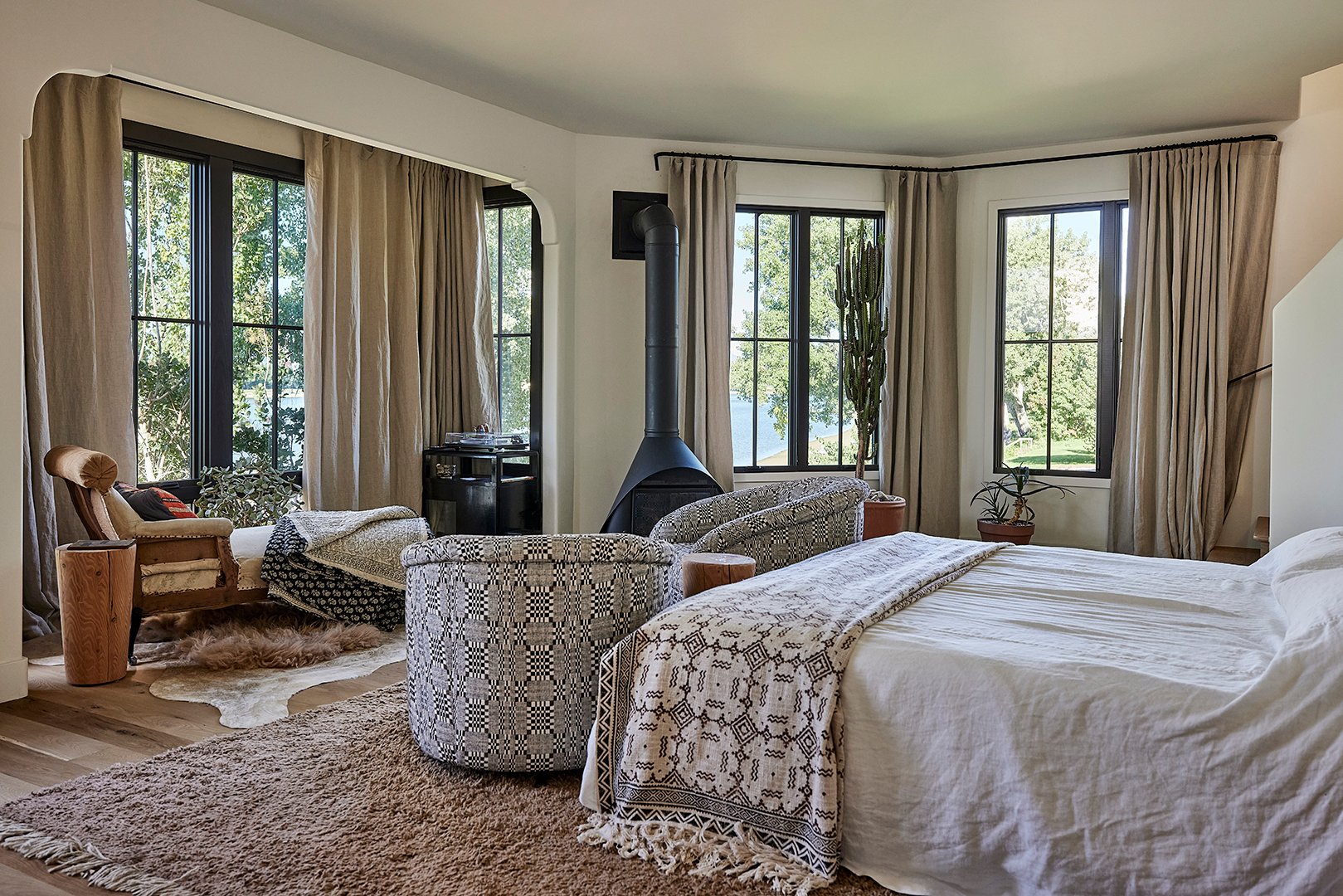 primary bedroom with chairs and bed and woodstove