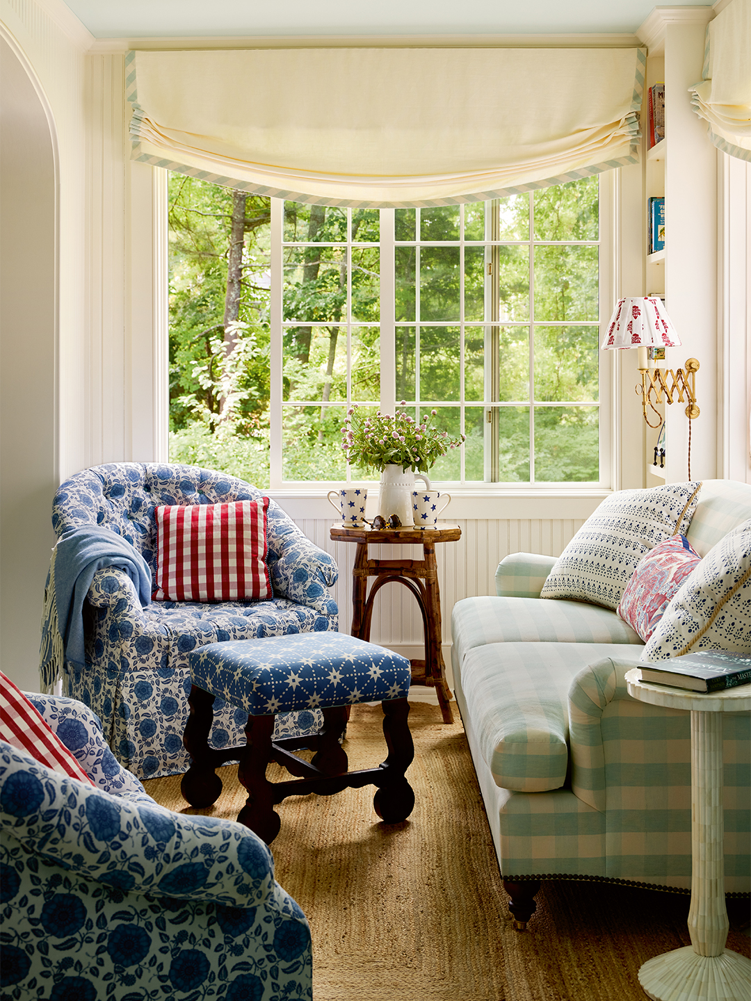 sunroom with green sofa, blue chair, bay window