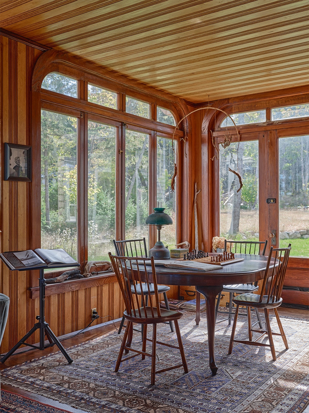 wood paneled sunroom with a small table and chairs