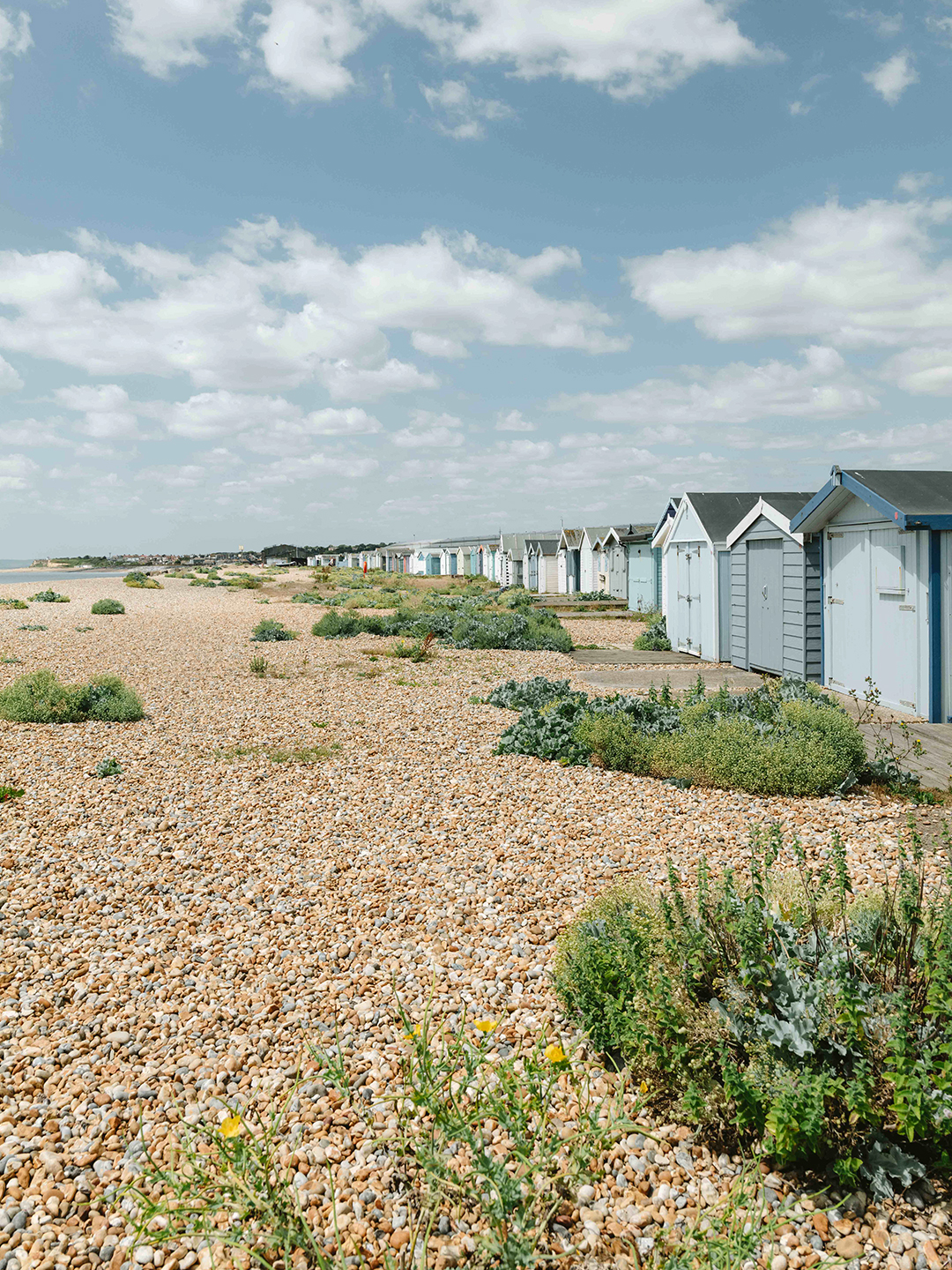 a row of beach huts and a rocky beach