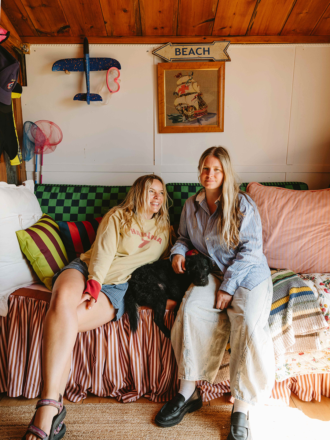 two women sitting on a sofa in a beach hut