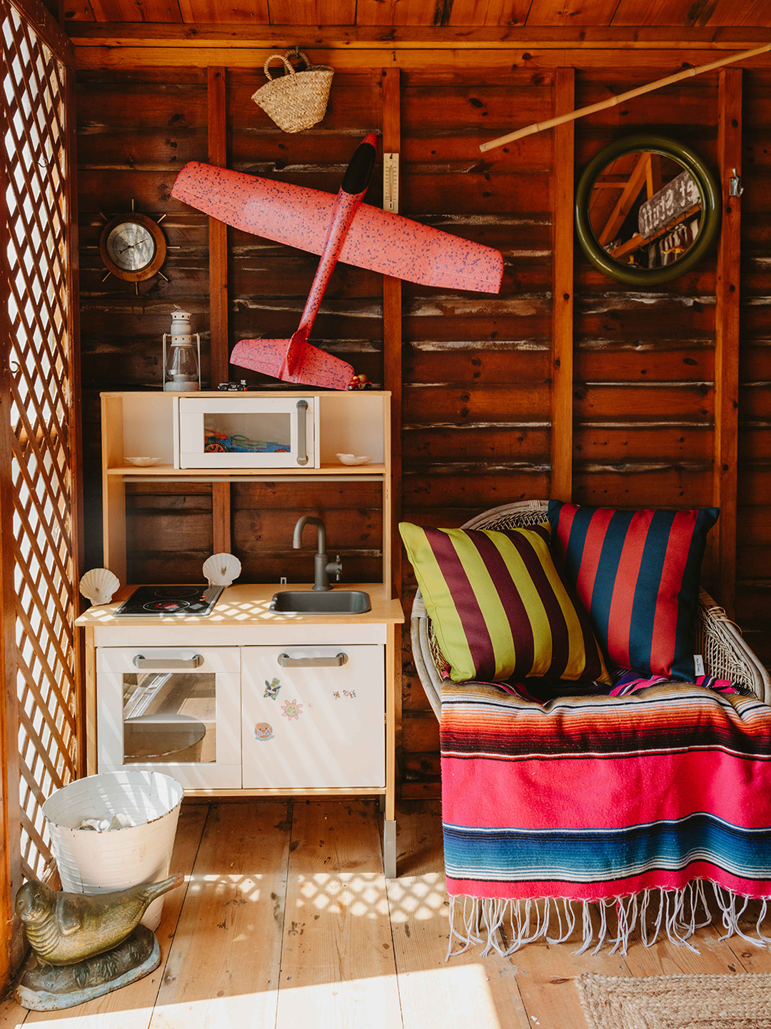 interior of colorful beach hut with lots of striped fabrics and little child's play kitchen
